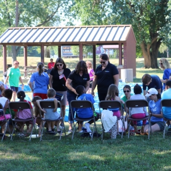 Volunteers helping children try on shoes