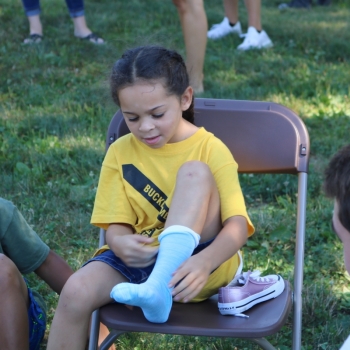 A young female child trying on socks