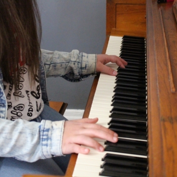 Arelis playing piano, close-up on hands