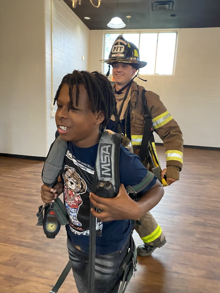 Student carrying firefighter gear