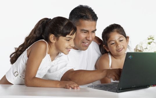 Father with two daughters on a laptop